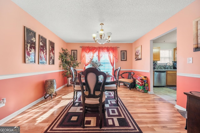 dining area featuring plenty of natural light, a notable chandelier, and light hardwood / wood-style floors