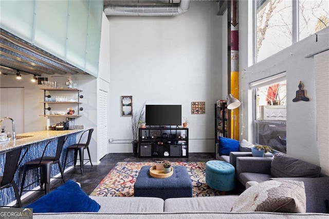 living room with indoor wet bar and a high ceiling