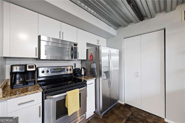 kitchen featuring dark stone countertops, beam ceiling, white cabinets, and appliances with stainless steel finishes