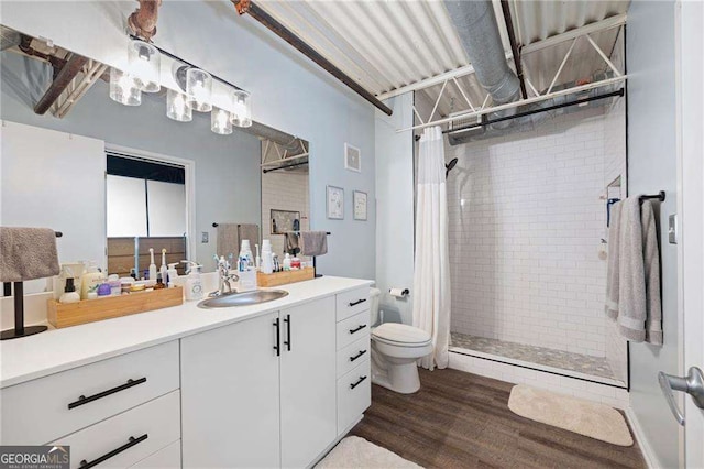 bathroom featuring vanity, hardwood / wood-style flooring, curtained shower, and toilet