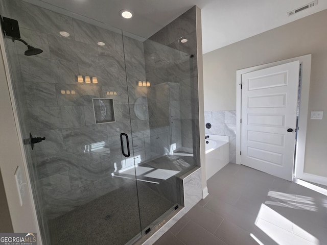 bathroom with tile patterned flooring and shower with separate bathtub