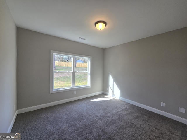 unfurnished room featuring dark colored carpet