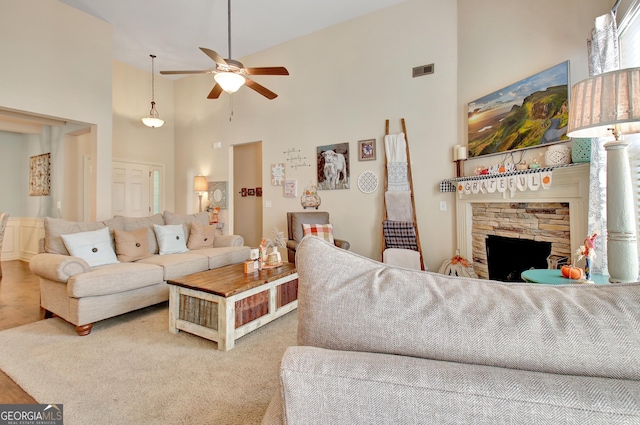 living room featuring a fireplace, high vaulted ceiling, and ceiling fan