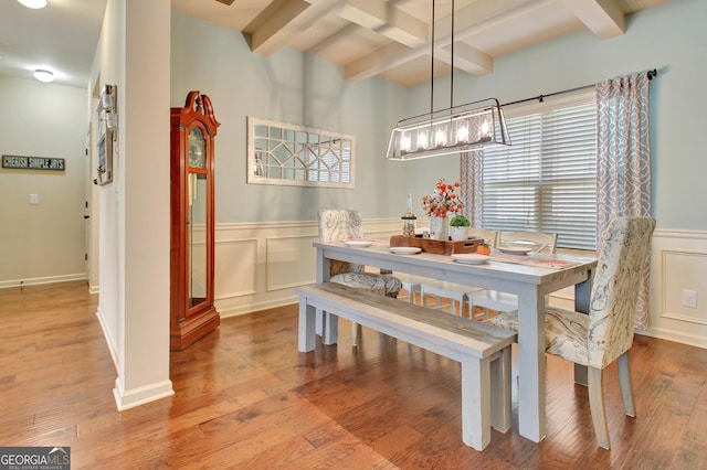 dining room with beam ceiling and light wood-type flooring