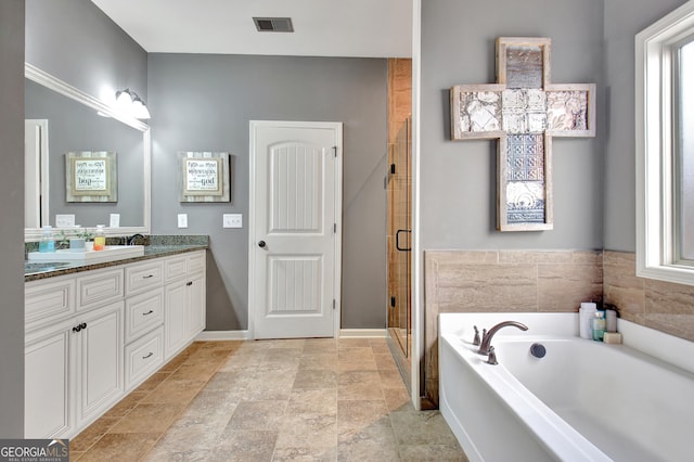 bathroom with vanity and shower with separate bathtub