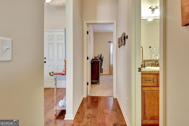 hall with sink and light wood-type flooring