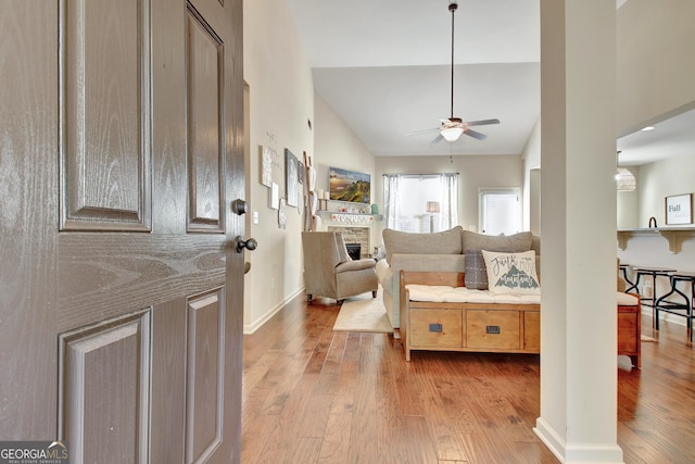 entryway with vaulted ceiling, ceiling fan, and light wood-type flooring