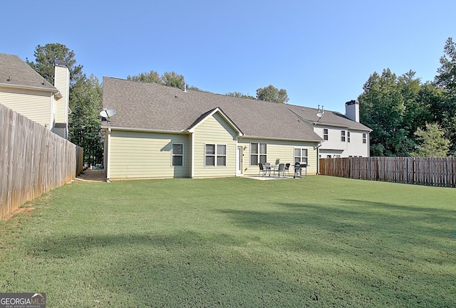 rear view of property featuring a yard and a patio