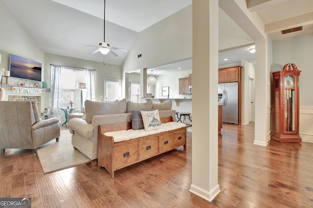 living room featuring hardwood / wood-style floors, high vaulted ceiling, and ceiling fan