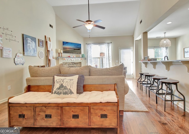 living room featuring ceiling fan, high vaulted ceiling, and light hardwood / wood-style floors