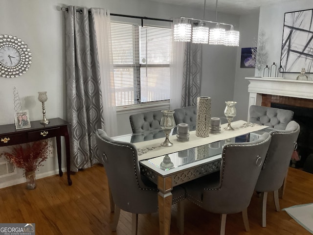 dining area with hardwood / wood-style floors and a notable chandelier