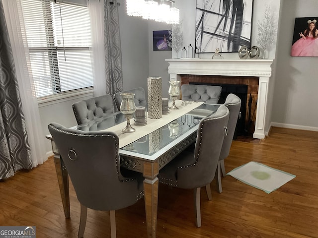 dining area with a tiled fireplace and hardwood / wood-style floors