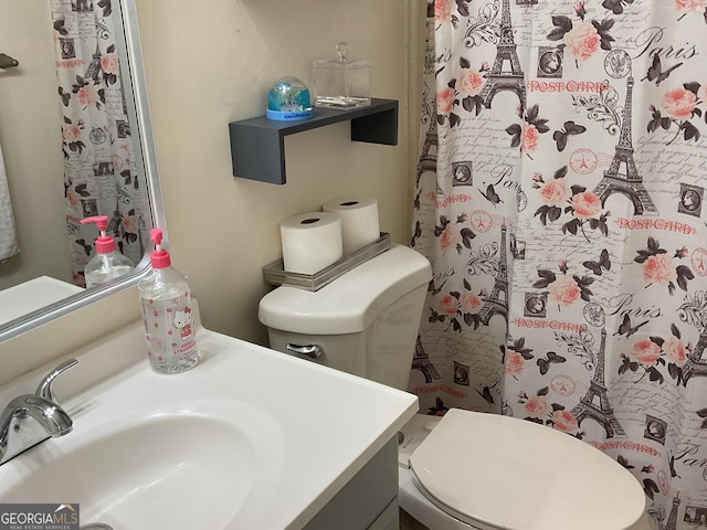 bathroom featuring vanity, curtained shower, and toilet