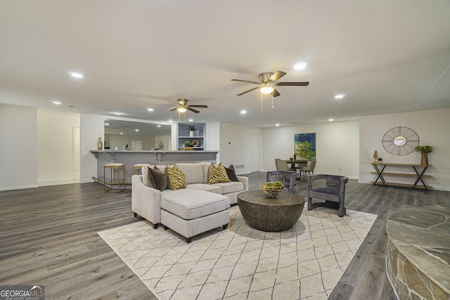 living area featuring baseboards, wood finished floors, recessed lighting, and ceiling fan