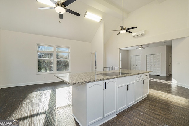 kitchen featuring a center island, a ceiling fan, open floor plan, black electric cooktop, and white cabinets