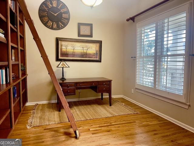 office area with plenty of natural light, baseboards, and wood finished floors