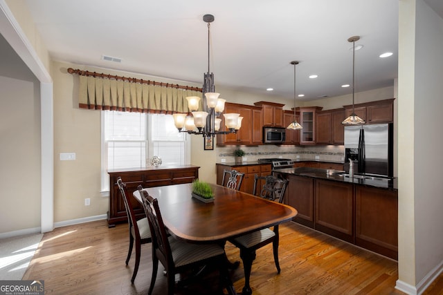 dining space with baseboards, visible vents, light wood-style floors, a chandelier, and recessed lighting