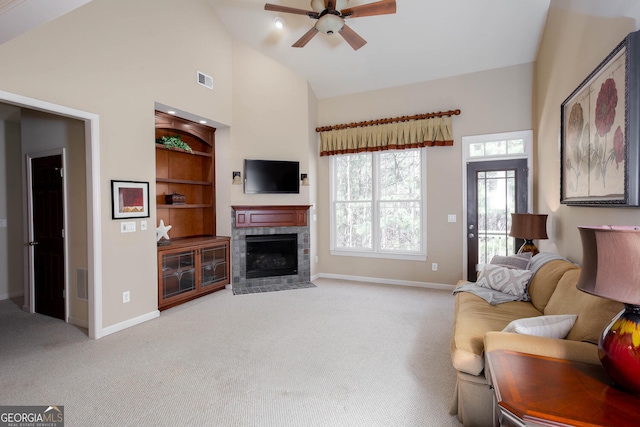 living area with baseboards, built in features, a ceiling fan, light colored carpet, and high vaulted ceiling