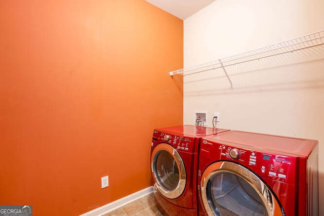 laundry area featuring washing machine and dryer, laundry area, baseboards, and tile patterned floors