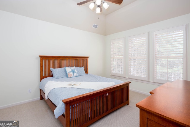 bedroom featuring lofted ceiling, light carpet, and baseboards