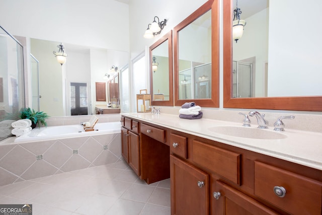 full bathroom featuring a garden tub, a stall shower, tile patterned flooring, and a sink