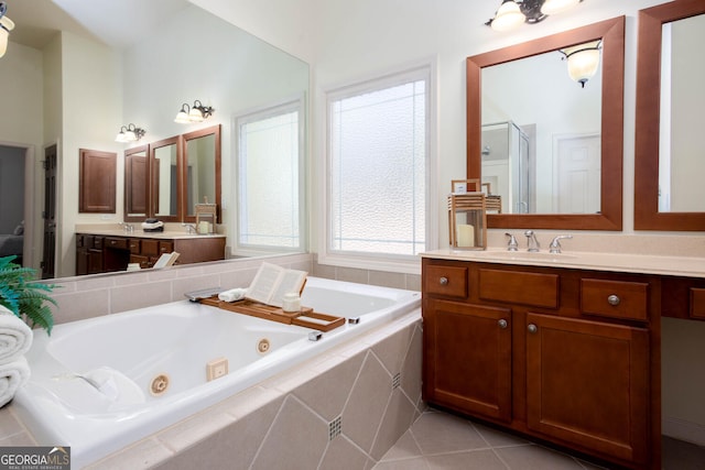 bathroom with a tub with jets, a stall shower, tile patterned flooring, and vanity