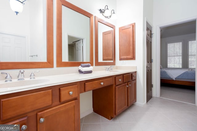 ensuite bathroom with ensuite bathroom, double vanity, a sink, and tile patterned floors