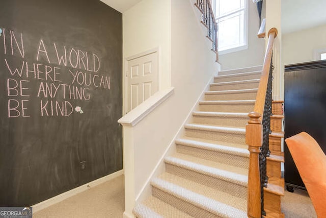 stairway featuring carpet floors and baseboards