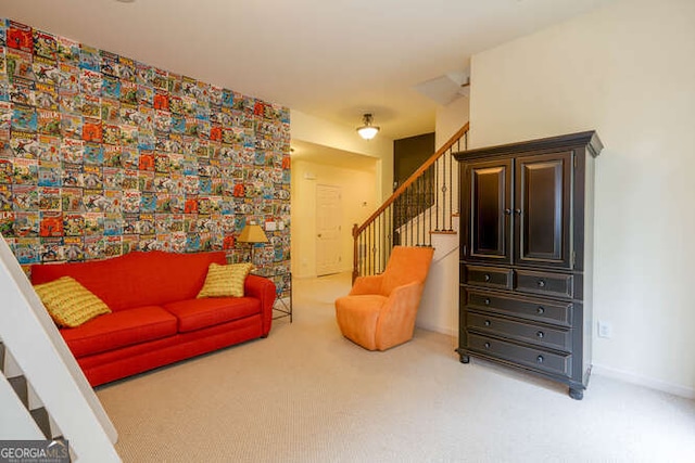 sitting room with stairs, carpet floors, and baseboards