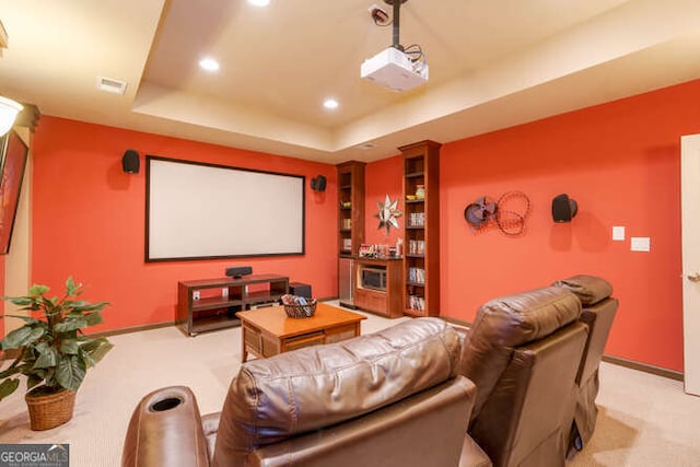 cinema room featuring a tray ceiling, light carpet, baseboards, and recessed lighting