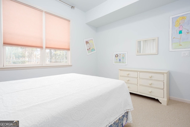 bedroom featuring light colored carpet and baseboards