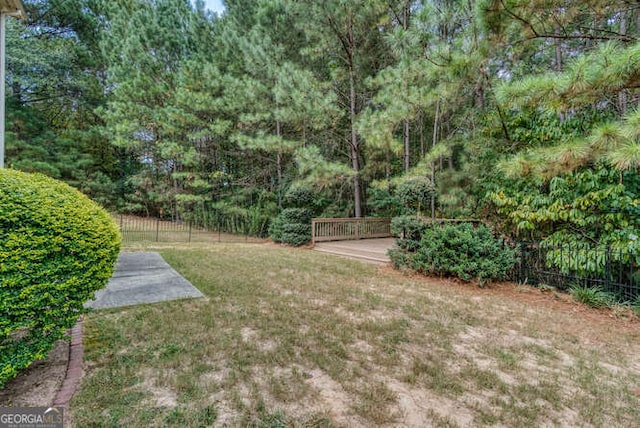 view of yard featuring fence and a deck