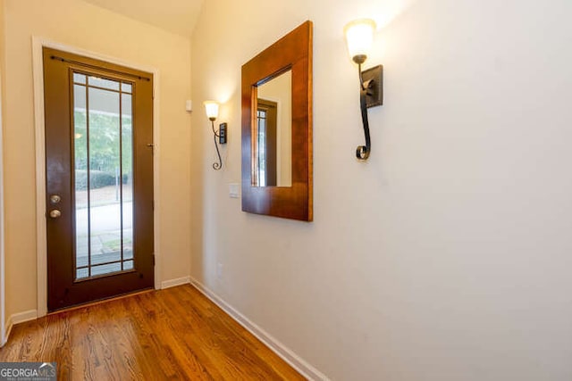 doorway to outside with baseboards and wood finished floors