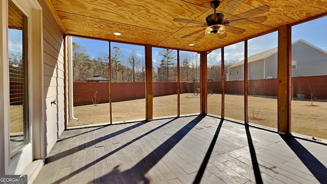 unfurnished sunroom featuring ceiling fan, a wealth of natural light, and wooden ceiling