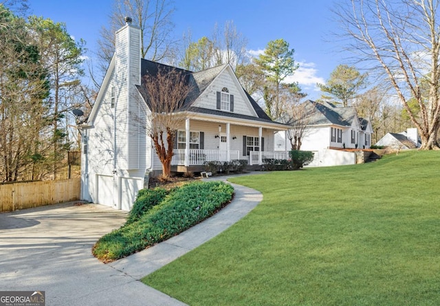 view of front of home with a garage, covered porch, and a front lawn