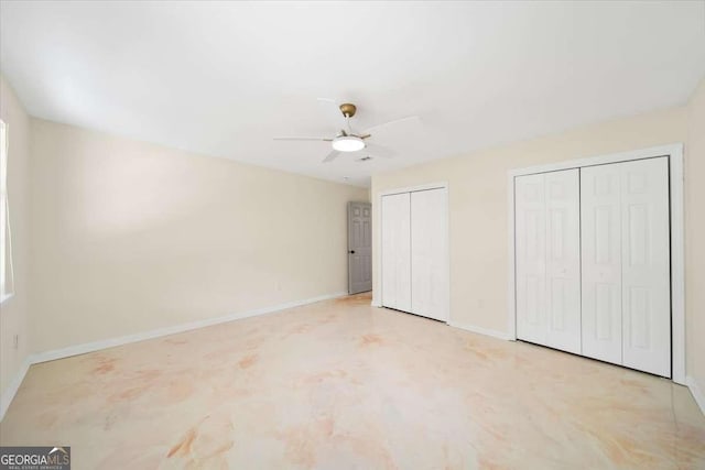 unfurnished bedroom featuring two closets and ceiling fan