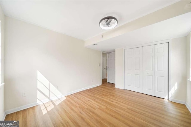 unfurnished bedroom featuring light hardwood / wood-style flooring and a closet