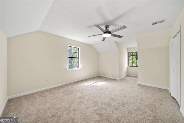 bonus room with light carpet, vaulted ceiling, and ceiling fan