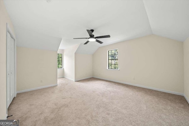 bonus room with lofted ceiling, a healthy amount of sunlight, and light carpet