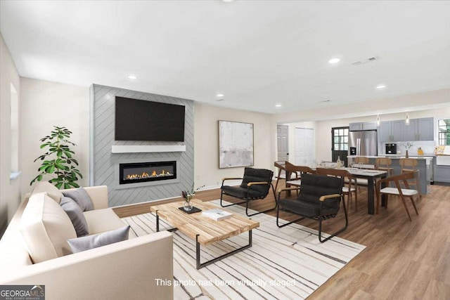 living room with a fireplace and light hardwood / wood-style flooring