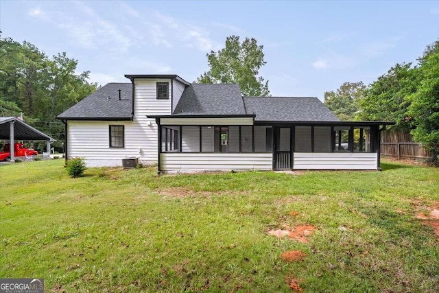 rear view of property featuring a sunroom, a yard, and central air condition unit