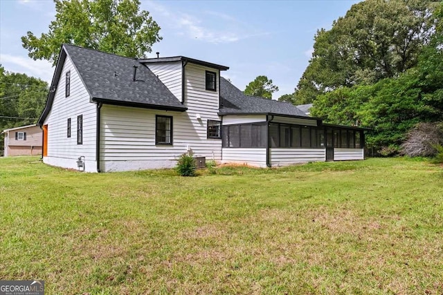 rear view of house with a yard and a sunroom