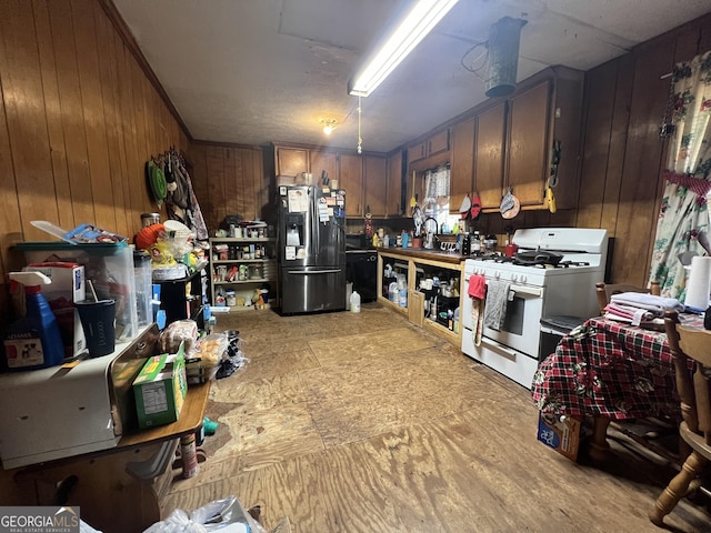 interior space featuring fridge with ice dispenser and wood walls