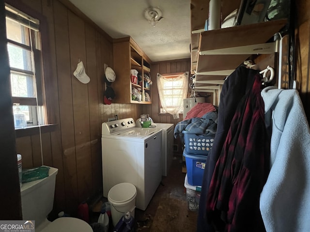 washroom with washing machine and clothes dryer, laundry area, and wooden walls