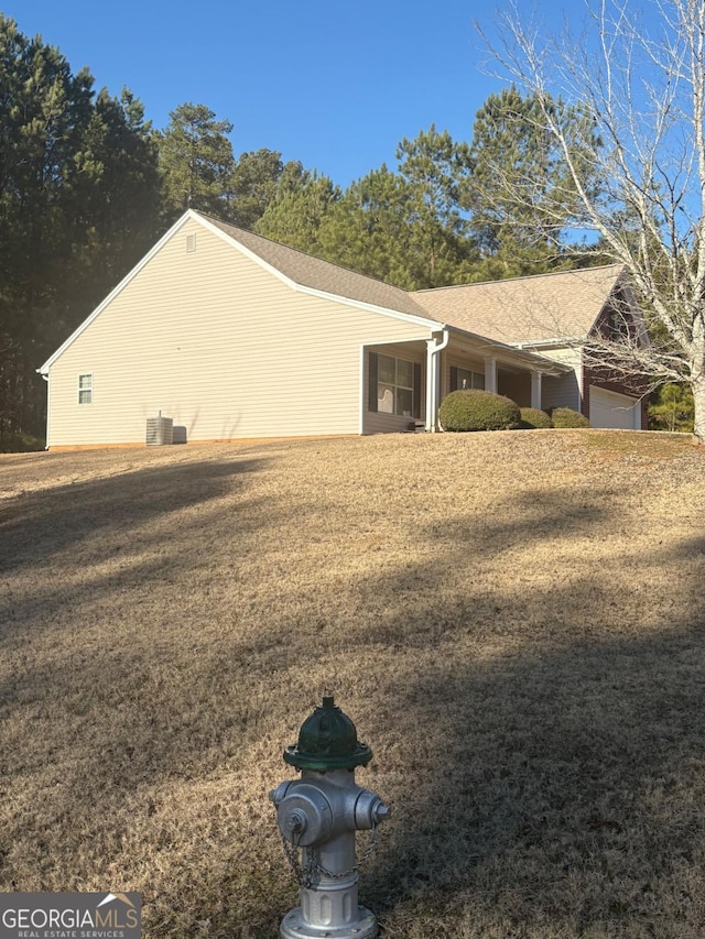 view of side of property with cooling unit and a yard