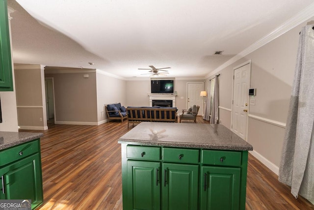 kitchen with crown molding, a center island, ceiling fan, and green cabinetry