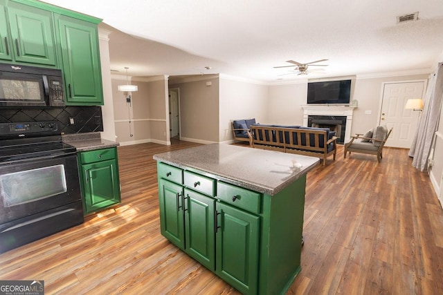 kitchen featuring crown molding, black appliances, and green cabinetry