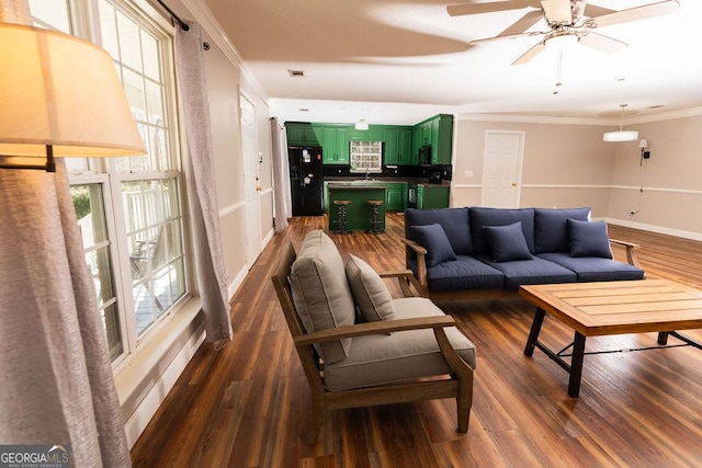 living room with crown molding, ceiling fan, dark hardwood / wood-style floors, and sink