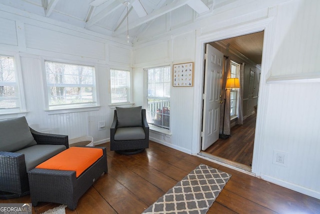 living area featuring dark wood-type flooring, a healthy amount of sunlight, and lofted ceiling with beams