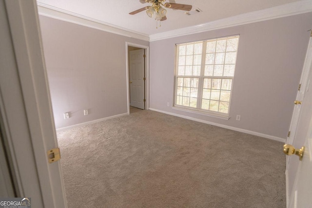 empty room with crown molding, carpet floors, and ceiling fan